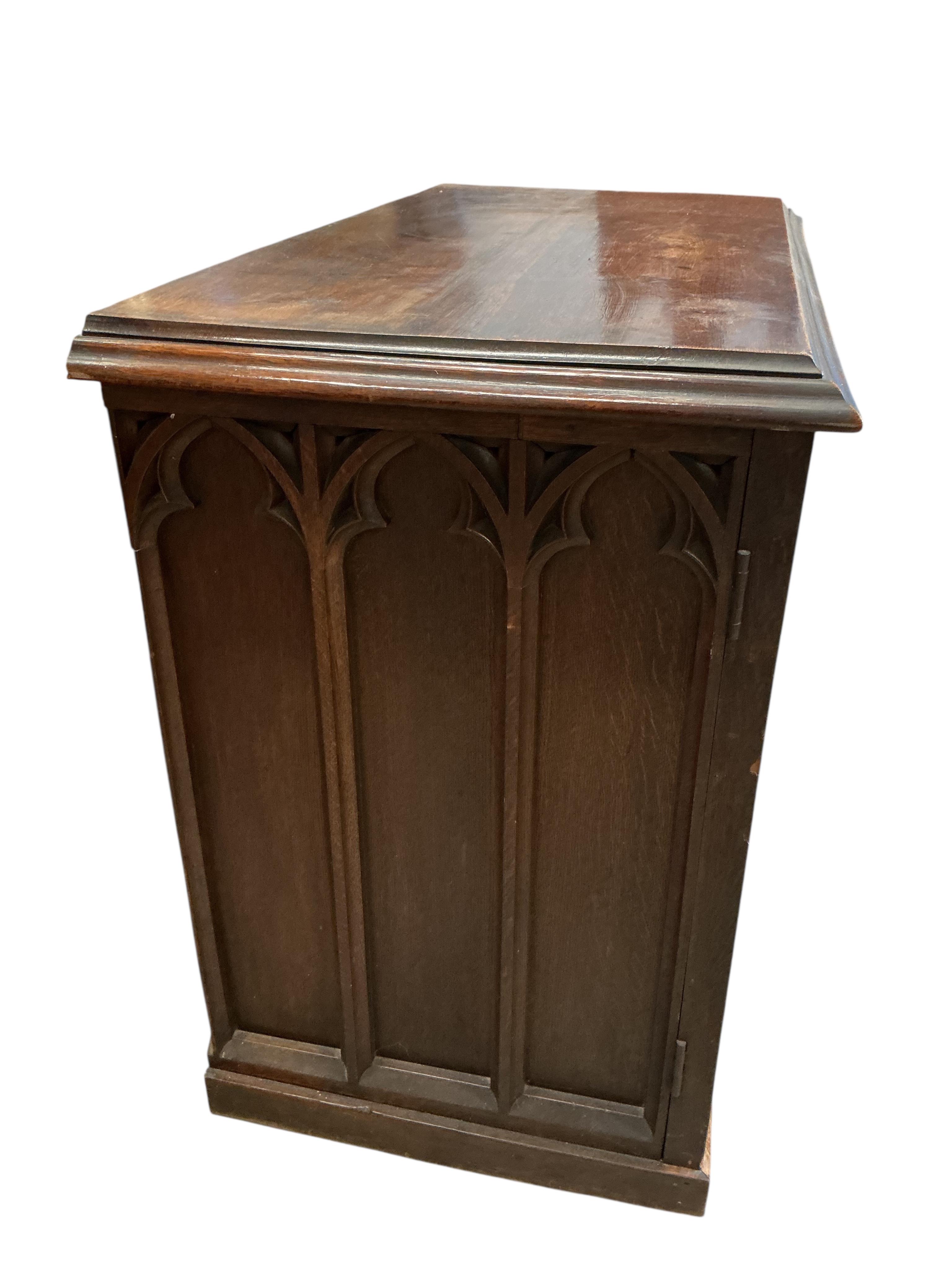 A late Victorian Gothic style oak two door side cabinet, width 122cm, depth 62cm, height 94cm